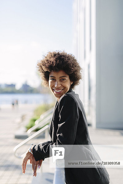 USA  New York City  portrait of smiling businesswoman leaning on railing