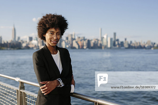 USA  New York City  Portrait einer Geschäftsfrau vor der Skyline