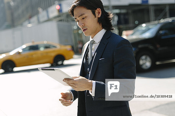 USA  New York City  businessman looking at digital tablet in Manhattan