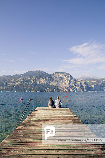 Italien  Venetien  Malcesine  Bordell und Schwester am Steg sitzend