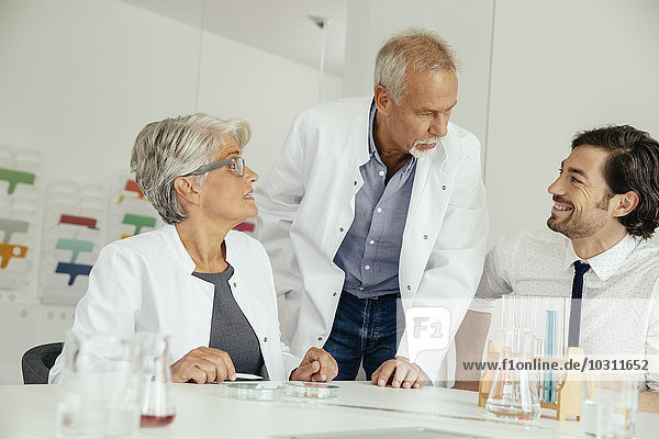 Three scientists talking in lab