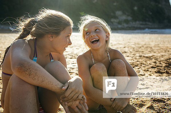 Two sisters having fun together on the beach