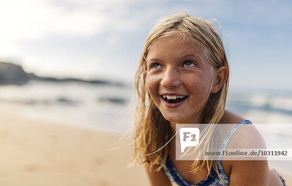 Portrait of smiling blond girl on the beach