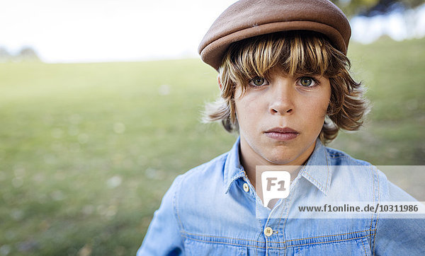 Porträt eines ernsthaft aussehenden blonden Jungen mit Mütze