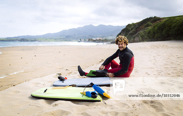 Spanien  Asturien  Colunga  Bodyboardfahrer bei der Vorbereitung am Strand