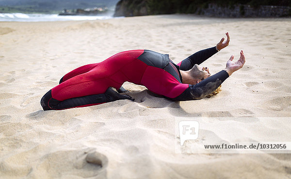 Spain  Asturias  Colunga  surfer stretching on the beach