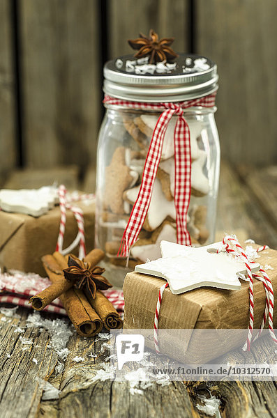 Einmachglas mit selbstgebackenen Zimtsternen und Weihnachtsgeschenken