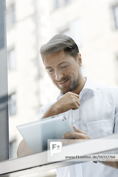 Porträt eines Geschäftsmannes beim Betrachten eines digitalen Tabletts
