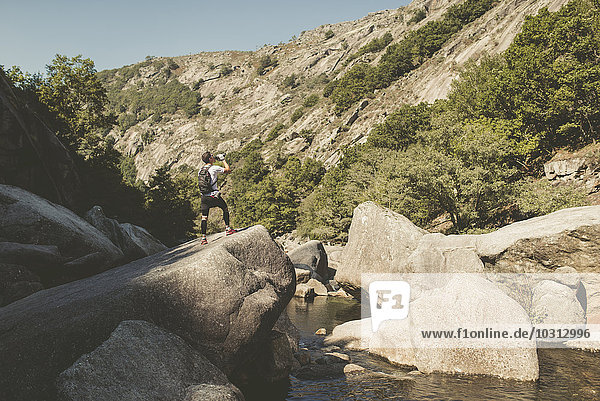 Spanien  Galizien  A Capela  Ultra Trail Runner beim Trinken an der Schlucht des Eume Flusses