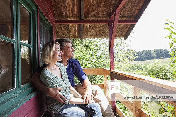 Glückliches reifes Paar auf der Veranda des Sommerhauses