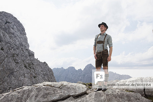 Deutschland  Bayern  Osterfelderkopf  Mann in traditioneller Kleidung steht in Berglandschaft