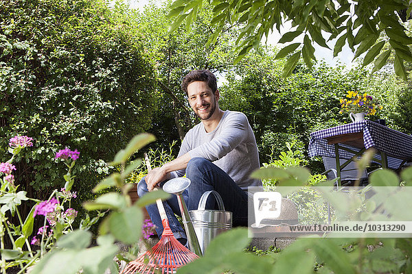 Smiling man sitting on garden terrace