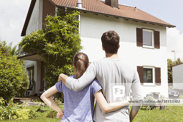 Couple in garden looking at residential house