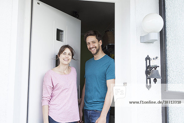 Porträt des lächelnden Paares vor der Haustür