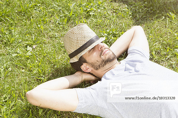 Mann auf dem Rasen liegend entspannend