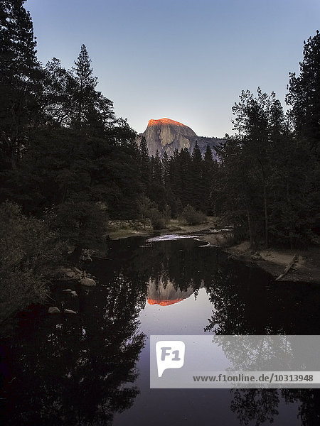 USA  Kalifornien  Yosemite Nationalpark  Sonnenuntergang bei Half Dome  Spiegelung im Wasser