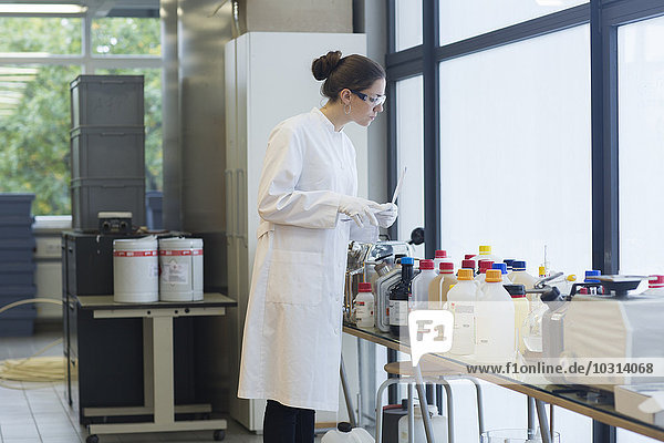 Junge Wissenschaftlerin auf der Suche nach etwas in einem Chemielabor