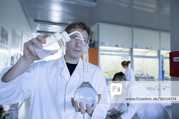Drei Chemiker,  die in einem chemischen Labor arbeiten