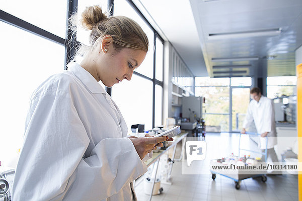 Young female chemist using digital tablet in a chemical laboratory