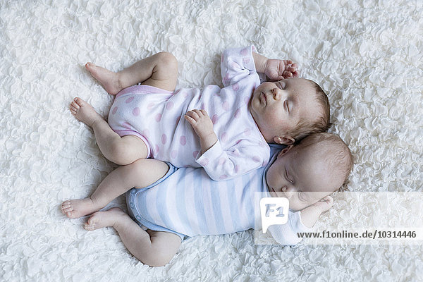 Neugeborene Zwillinge schlafen Seite an Seite