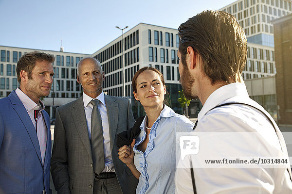 Four smiling businesspeople outdoors
