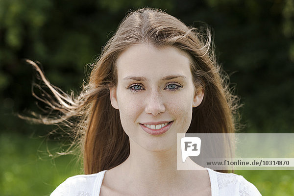 Portrait of smiling young woman with blowing hair