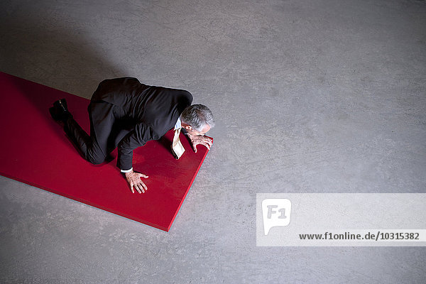 Businessman kneeling on floor