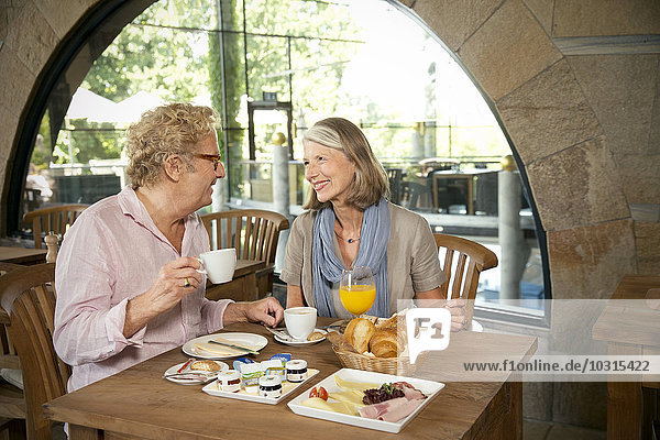 Lächelndes Seniorenpaar beim Frühstück im Cafe