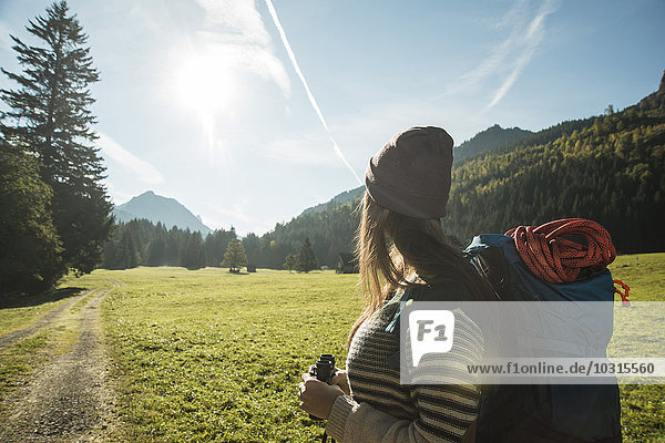 Austria  Tyrol  Tannheimer Tal  young female hiker with binocular and backpack watching landscape