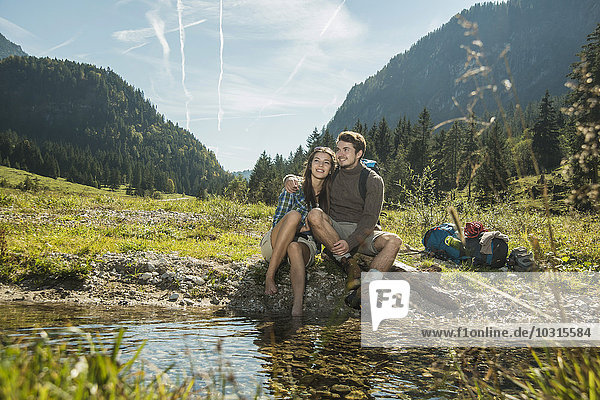 Austria  Tyrol  Tannheimer Tal  two happy young hikers relaxing
