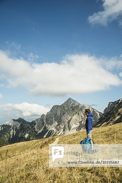 Austria  Tyrol  Tannheimer Tal  hiker with backpack on alpine meadow