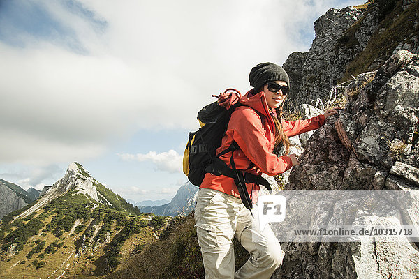 Austria  Tyrol  Tannheimer Tal  young woman hiking on rock