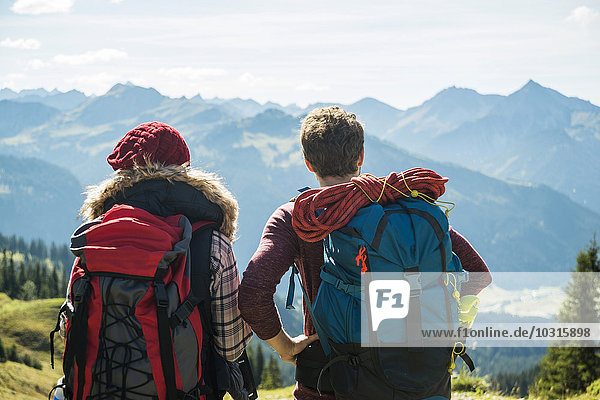 Austria  Tyrol  Tannheimer Tal  young couple in mountains looking at view