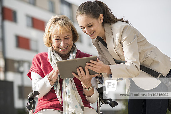 Enkelin und Großmutter beim Betrachten des digitalen Tabletts
