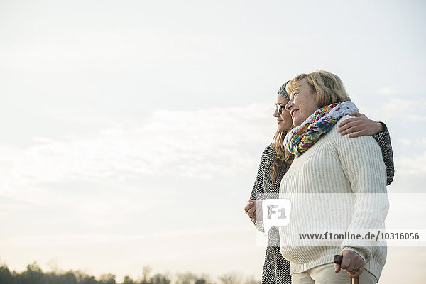 Young woman and her grandmother watching sunset