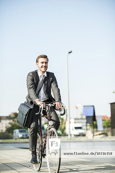 Young businessman riding bicycle