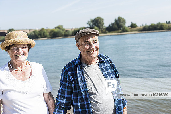 Germany  Ludwigshafen  portrait of happy senior couple at riverside