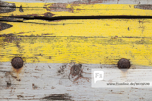 Verwittertes Holzbrett mit gelber und grauer Farbe  Nahaufnahme