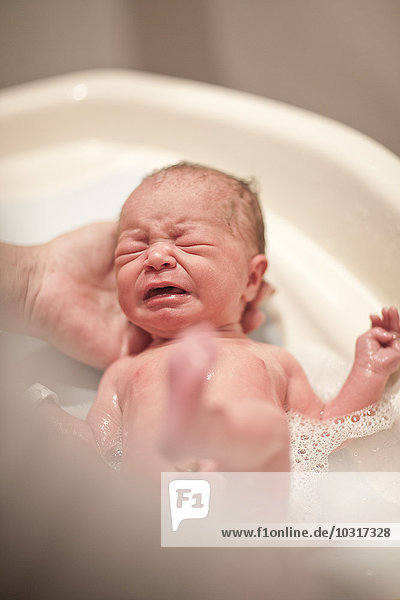 Newborn baby is being bathed