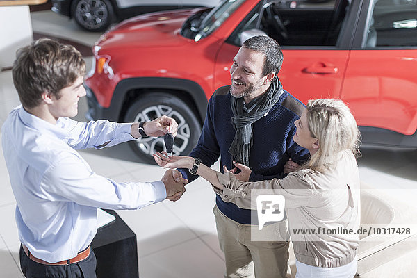 Autohändler übergibt Schlüssel an den Kunden