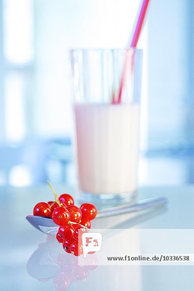 Johannisbeeren (rot) auf Teelöffel - Unscharfes Milchglas im Hintergrund - Rote Johannisbeere - Ribes rubrum - Inhalt Tücher: C-Vitamin - A-Vitamin - Zitronensäure - Verwendung bei Gicht - Rheuma - Häusliche Küche - Milch enthält Vitamin B1  B12 und C-Vitamin sowie Magnesium  Kalzium und Eiweiß - sie wird für den Zahn- und Knochenbau verwendet