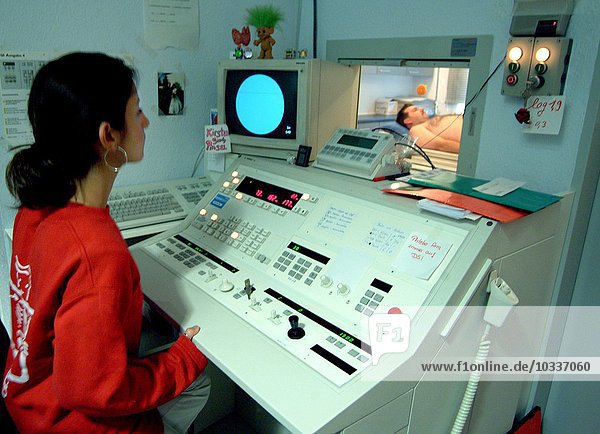 Röntgenarzt bedient Röntgengerät mit Blick auf den Patienten