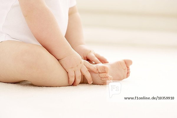 Baby hält ihre Füße