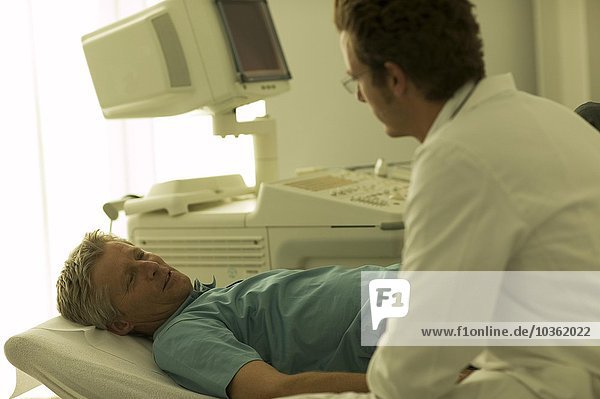 Männlicher Arzt im Gespräch mit einem Patienten