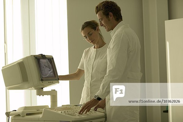Arzt und Krankenschwester vor einem Ultraschallgerät