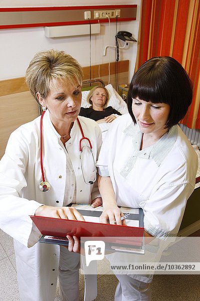 Arzt und Krankenschwester sprechen über eine Patientin in einem Krankenhaus