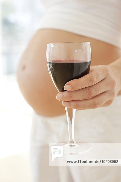 Schwangere Frau mit einem Glas Wein