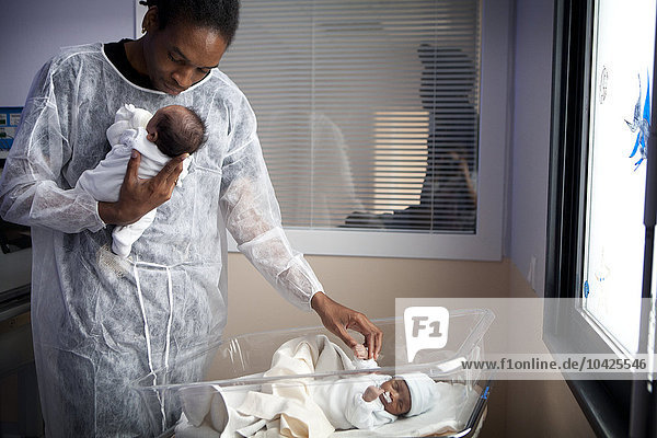 Fotoessay im Krankenhaus Saint Maurice in Frankreich. Abteilung für Neonatologie eine Woche nach der Geburt der Zwillinge. Der Vater kümmert sich um die Zwillinge. Durch das Fenster können die Familien die Neugeborenen sehen.