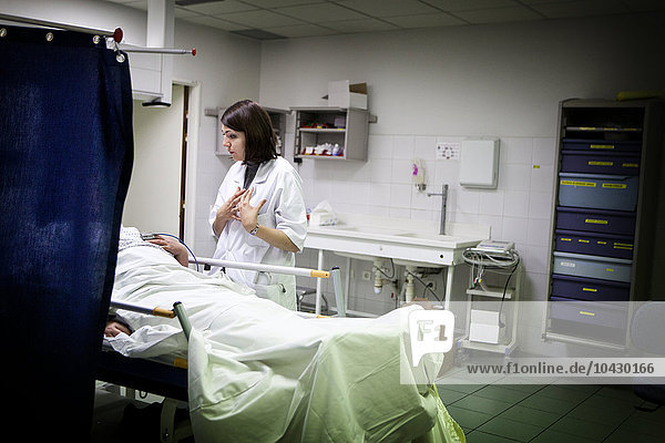 Reportage in der Notaufnahme des Allgemeinkrankenhauses Robert Ballanger  Frankreich. Ein Assistenzarzt spricht mit einem Patienten im Traumazentrum.