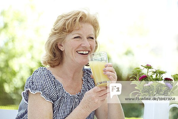 MODEL RELEASED. Woman drinking fruit juice.
